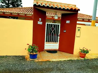 a red house with a gate and two potted plants at Casa Con Piscina Privada Marenyet in Cullera