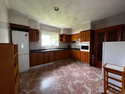 a kitchen with wooden cabinets and a white refrigerator at Casa Con Piscina Privada Marenyet in Cullera