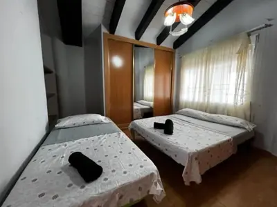 a bedroom with two beds and a mirror and a window at Casa Con Piscina Privada Marenyet in Cullera