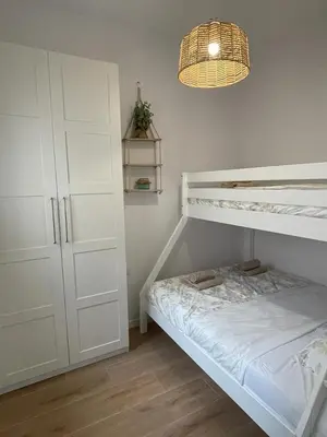 a bedroom with a white bunk bed and a lamp at UIM Mediterraneo CASA Virgen de los Dolores Wifi in Puerto de Sagunto