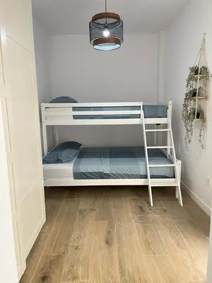 a white bunk bed in a room with a wooden floor at UIM Mediterraneo CASA Virgen de los Dolores Wifi in Puerto de Sagunto