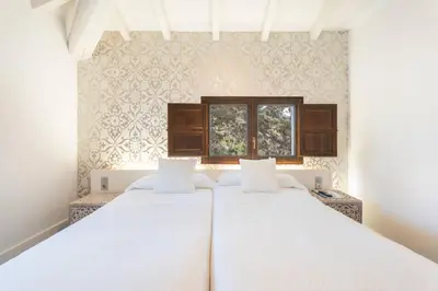 a white bedroom with a bed with a blue blanket at 1893 Hotel Boutique in Navajas