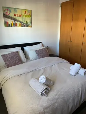 a large white bed with two towels on it at PLAYA ALMENARA ATICO DUPLEX VISTAS AL MAR Y MONTAÑA WIFI,PISCINA a in Almenara