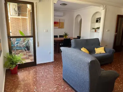a blue couch with yellow pillows in a living room at Borriana Bonica in Burriana