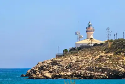 a lighthouse sitting on top of a rocky island at veronica in Llaurí