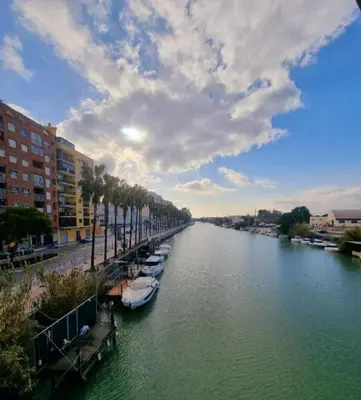 a river with boats docked next to some buildings at veronica in Llaurí