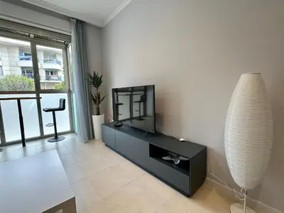 a living room with a tv and a table at Reinapart Patacona Beach 36 in Valencia