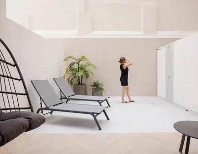 a woman in a black dress standing in a room at Blanq Ruzafa in Valencia