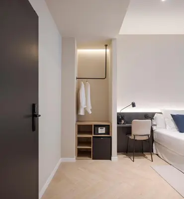 a bedroom with a bed and a desk with a chair at Blanq Ruzafa in Valencia