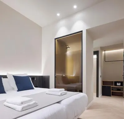 a bedroom with a large white bed with blue accents at Blanq Ruzafa in Valencia