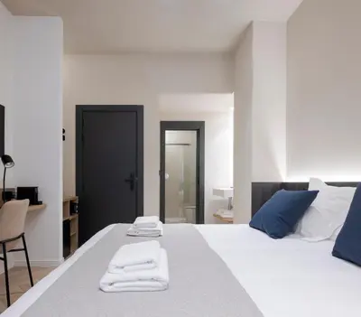 a bedroom with a white bed with towels on it at Blanq Ruzafa in Valencia