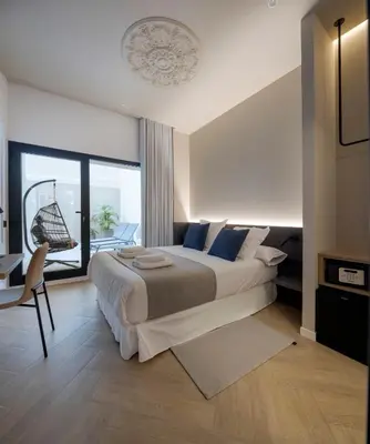 a bedroom with a large bed and a balcony at Blanq Ruzafa in Valencia