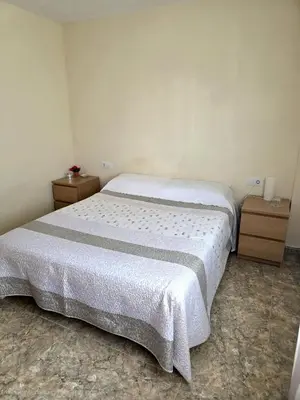 a bed in a room with two nightstands and a bed sidx sidx sidx at Vivienda Particular Cerca de Valencia in Paterna