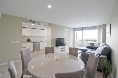 a living room with a white table and chairs at Global Vacacional, Moderno apartamento con 2 terrazas y 3 habitaciones in Canet de Berenguer