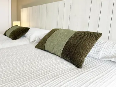 a bed with two pillows on top of it at Global Vacacional, Moderno apartamento con 2 terrazas y 3 habitaciones in Canet de Berenguer