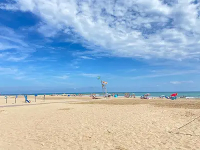 a group of people on a beach with the ocean at Escápate al Sol Apartamento con Piscina y Playa Cercana in Playa Pobla de Farnals