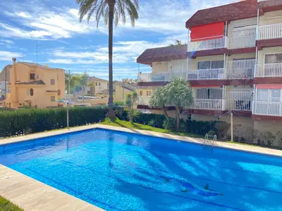 a swimming pool in front of a building at Escápate al Sol Apartamento con Piscina y Playa Cercana in Playa Pobla de Farnals