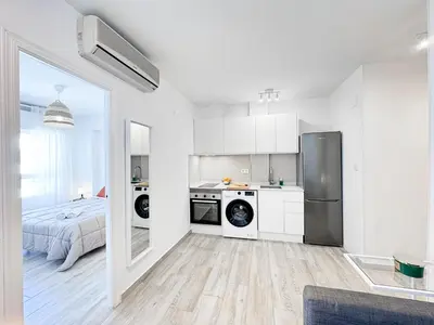 a kitchen with a washer and dryer in a room at NUEVO, a 50 metros de la playa y con vistas al mar in Cullera