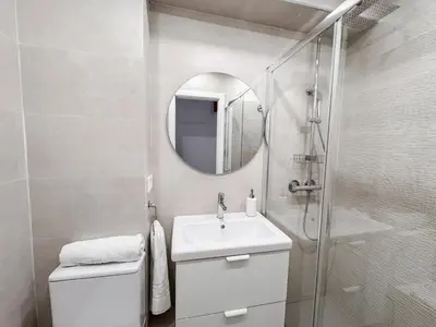 a white bathroom with a sink and a shower at NUEVO, a 50 metros de la playa y con vistas al mar in Cullera