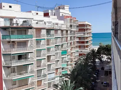 a tall apartment building with the ocean in the background at NUEVO, a 50 metros de la playa y con vistas al mar in Cullera