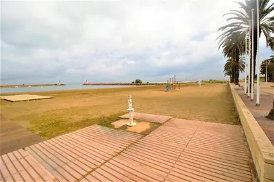 a sandy beach with a playground and the ocean at Sun & Sea Puebla in Puebla de Farnals