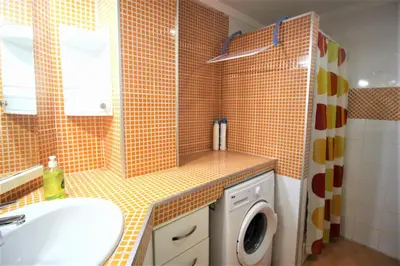 a bathroom with a sink and a washing machine at Sun & Sea Puebla in Puebla de Farnals