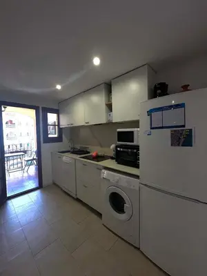 a kitchen with white cabinets and a washer and dryer at Port Saplaya 3 habitaciones Valencia in Port Saplaya