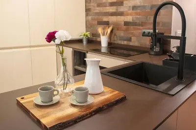a kitchen counter with two cups and a vase with flowers at Lujoso Hogar cerca del Casco Antiguo de la ciudad in Valencia