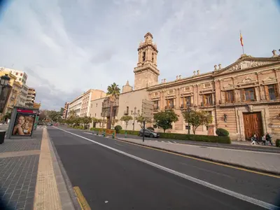 an empty street in front of a building with a clock tower at MD Iturbi Jardin Turia in Valencia