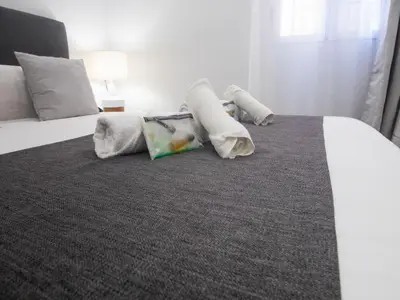 a bed with white pillows and a book on it at MD Iturbi Jardin Turia in Valencia