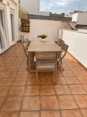 a wooden table and chairs on a patio at UIM Mediterraneo ATICO Hipanidad 1 WIFI in Puerto de Sagunto