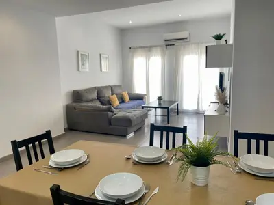 a living room with a table and a couch at UIM Mediterraneo ATICO Hipanidad 1 WIFI in Puerto de Sagunto