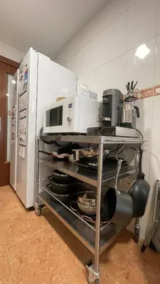 a microwave sitting on a cart next to a refrigerator at Work and Rest Away From Home in Paterna