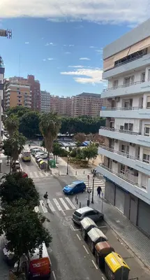 a city street with cars parked in front of a building at Arts & Sciences Rooms - Valencia Authentic Urban Parklife - VLC Urban Rental in Valencia