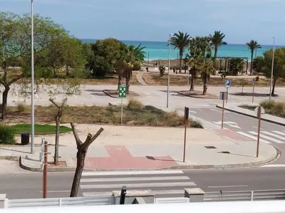 an empty street with palm trees and the ocean at Villa de lujo frente al mar in Barrio-Mar