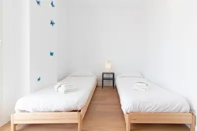 two twin beds in a room with white walls at Global Vacacional, Apartamento con terraza y vistas al mar in Canet de Berenguer