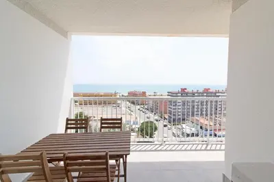 a dining room table with a view of a city at Global Vacacional, Apartamento con terraza y vistas al mar in Canet de Berenguer
