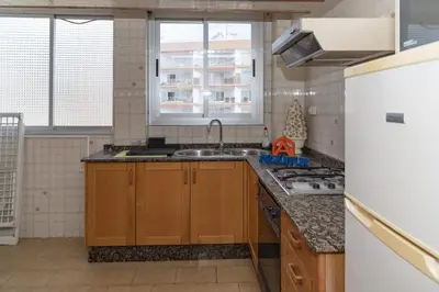 a kitchen with wooden cabinets and a sink at El Raco, A-8-16 in Cullera