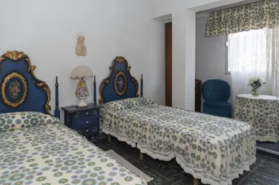 a bedroom with two beds and a blue chair at El Raco, A-8-16 in Cullera