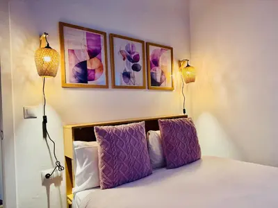 a bedroom with two lamps and a bed with purple pillows at Design & Stylish House in the CENTER of Valencia in Valencia