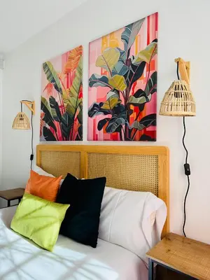 a bedroom with a bed with two paintings on the wall at Design & Stylish House in the CENTER of Valencia in Valencia