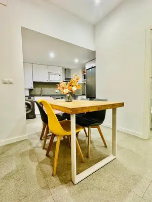 a dining room table with chairs and a vase of flowers at Design & Stylish House in the CENTER of Valencia in Valencia