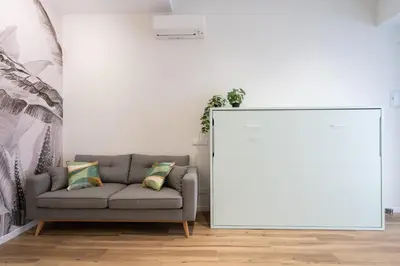 a living room with a couch and a large mirror at Marina Beach Apartments in Valencia