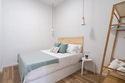 a white bedroom with a bed with a ladder at Marina Beach Apartments in Valencia