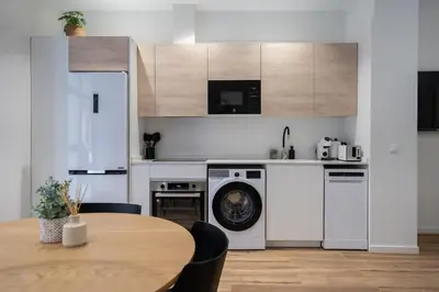 a kitchen with a table and a washing machine at Marina Beach Apartments in Valencia