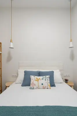 a white bed with two pillows and two lamps at Marina Beach Apartments in Valencia