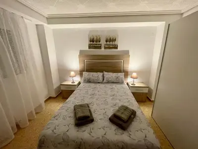 a bedroom with a large bed with two night stands at Sol y playa in Puerto de Sagunto