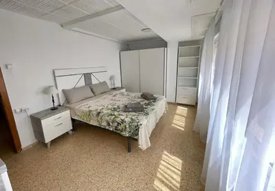 a small room with a table and a red bed at Sol y playa in Puerto de Sagunto