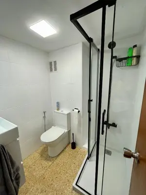a bathroom with a toilet and a glass shower door at Sol y playa in Puerto de Sagunto