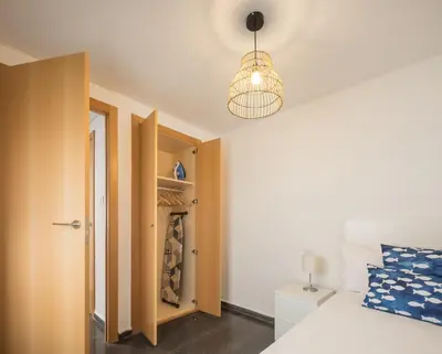 a bedroom with a bed and a closet at Macflats Ciudad de las Ciencias in Valencia